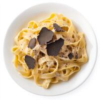 A plate of tagliatelle with truffle cream sauce, featuring long, flat noodles tossed in a rich and creamy sauce made with truffles, cream, and parmesan cheese, a luxurious and flavorful pasta dish, garnished with freshly shaved truffles, isolated on clean photo