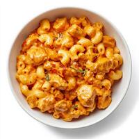 A bowl of classic American mac and cheese, elevated with the complex flavors of Indian butter chicken, featuring creamy macaroni pasta tossed in a rich tomato-based curry sauce with tender pieces of chicken, a unique and flavorful twist on comfort food, s photo