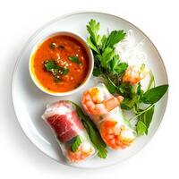 A plate with shrimp rolls, vegetables and sauce photo