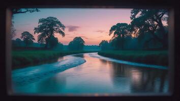 River Flowing Through a Lush Meadow at Sunset with Trees photo