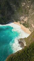 Aerial view of remote tropical beach with turquoise sea and dramatic cliffs on Nusa Penida, Bali, Indonesia. Ideal for travel, nature, summer, and scenic destination themes. video