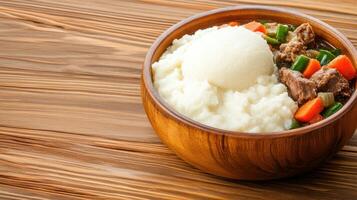 A hearty bowl of stew with creamy mashed potatoes on a wooden table, ready for a comforting dinner photo