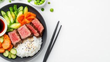 Balanced plate Medium steak slices, rice, carrots, cucumbers, and peas on a bright background. Use Editorial photo