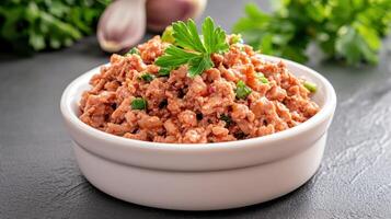 Bowl of ground meat on counter with parsley, garlic and herbs. Potential use cookbook photo