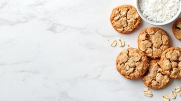 Cookies arranged with oats and shredded coconut on a marble surface, photographed from above with copy space photo