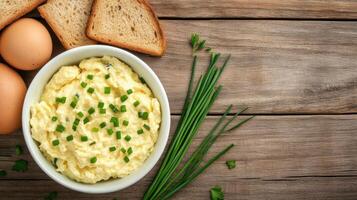 Egg salad bowl with bread slices on a rustic table, ideal for recipe blogs or culinary guides photo