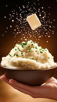 Mashed potatoes with butter and chives held in hand. Falling crumbs. Recipe use photo