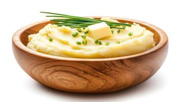 Mashed potatoes with butter and chives served in a wooden bowl on white background for recipe photo