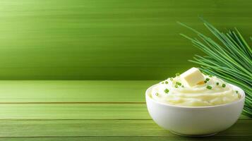 Mashed potatoes with butter and herbs on green background. Culinary concept, menu design photo