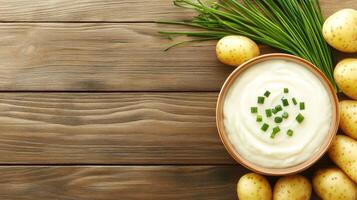 Mashed potatoes with chives on wood table, overhead shot. Restaurant menu, cookbook photo