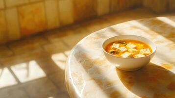 Miso soup steaming on a stone table with sunlight, used for menu or food blog ads photo
