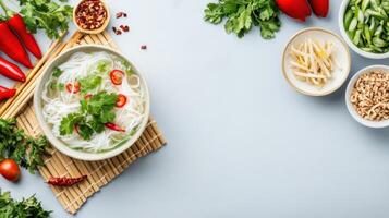 Noodle soup on mat surrounded by ingredients. Kitchen tabletop background. Recipe for cooking photo