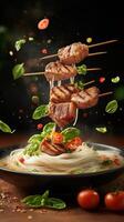 Noodles with grilled meat skewers and herbs, floating elements on a dark background for food blog photo