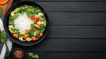 Overhead shot of veggie curry and rice in bowl on wood background with space for text for recipe blog photo