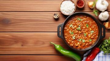 Overhead view of Chickpea Curry with rice and vegetables placed on wooden table for food blog photo