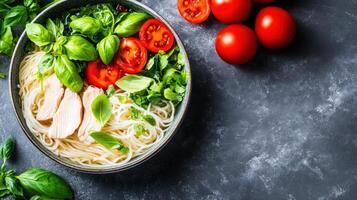 Pasta, chicken, and basil in bowl on table with tomatoes. Fresh, healthy meal for recipes photo