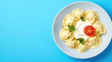 Pelmeni Overhead shot of dumplings with sauce tomato slice served on a blue plate for culinary use photo