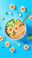 Ramen bowl with sliced egg and greens on blue surface for a food blog or cooking course image photo
