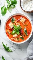 Red curry with tofu and basil on marble table, used for food blog or restaurant menu design photo