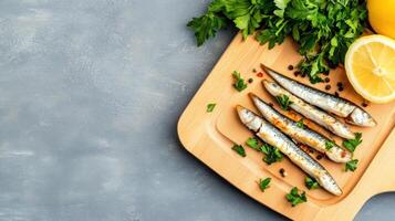 Sardines on a wooden board, garnished with parsley and pepper, with lemon. Copy space background for ad photo