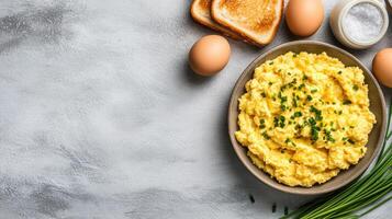 Scrambled eggs with chives on gray surface, toast eggs on the side for a nutrition blog photo