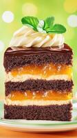 Slice of layered cake with filling topped with cream and mint on plate with bokeh background photo