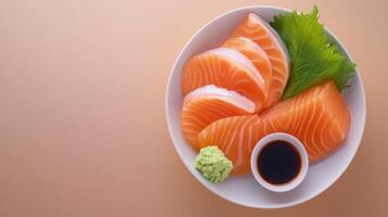 Slices of Salmon Sashimi on a plate with soy sauce, wasabi, and leaf for dinner photo