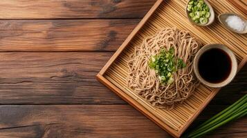 Soba noodles with soy and greens on bamboo tray with wood background. Possible culinary stock image photo