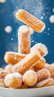 Stack of churros with sugar powder falling and a blue background. Possible use dessert recipe photo