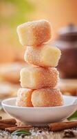 Stack of marzipan squares on a plate with cinnamon sticks on a wooden table background photo