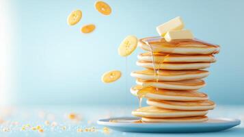Stack of pancake with banana toppings and butter with syrup flowing. For breakfast use photo