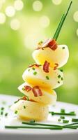 Stacked potato tower with bacon bits and chives garnish on a plate photo