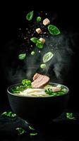 Steaming bowl of noodle soup with falling ingredients against a dark background. Use Food photography photo