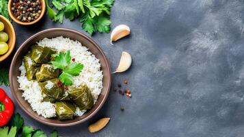Stuffed grape leaves with rice in bowl, on dark background. Restaurant menu, recipe book photo