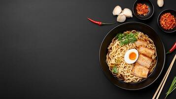 Tasty ramen bowl with egg and meat on a dark table, side dishes in the background. Food blog image photo