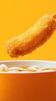 Tempura dipped into udon in a bright, minimalist setting, for food presentation and menu ideas photo