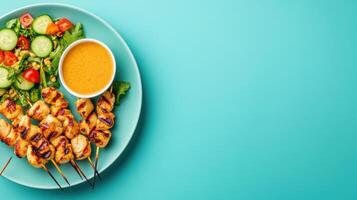 Top view of chicken skewers, salad and sauce on a plate, for restaurant menu use photo