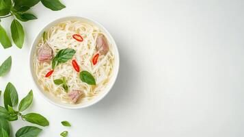 Top view of rice noodles soup with beef and basil on a clean white background for food photography photo