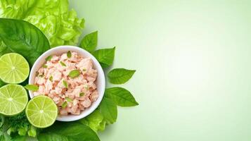 Tuna in bowl with lime and salad on green background for healthy eating and diet use photo