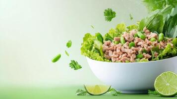 Tuna salad with greens, lime, and herbs in a white bowl. For menu ads and healthy eating blogs photo