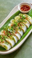 Vietnamese Banh Bot Loc dumplings served on leaf with chili sauce on a table. Possibly food blog photo
