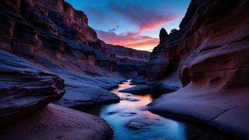 River Flowing Through Rocky Canyon at Sunset with Colorful Clouds photo