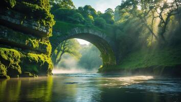 River Flowing Under Stone Bridge Surrounded by Greenery and Mist photo
