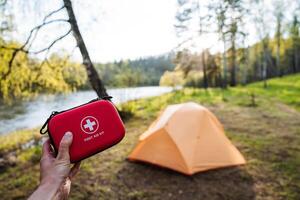 When embarking on an exciting adventure, it is essential to pack the right gear, particularly a solid first aid kit and a durable tent set up by the scenic river to ensure both safety and tranquility photo