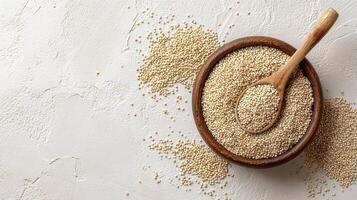Quinoa, sesame seeds, and brown spoon on white background photo