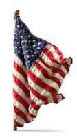 Waving fabric American flag displayed on a wooden pole in an outdoor setting under bright sunlight photo