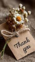 Beautiful thank you note with dried flowers on rustic fabric background photo