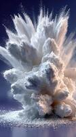Cloud of white powder explodes dramatically in a spectacular display against a dark background photo