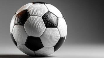 Soccer ball on a neutral background showcasing its textured surface and classic black and white design photo