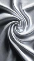 Elegant silver fabric with intricate texture swirling in a smooth pattern under soft light during daytime photo